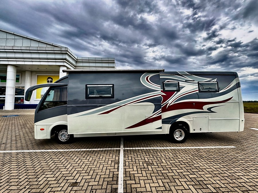 Motorhome visto de lado, toldo elétrico aberto, céu nublado